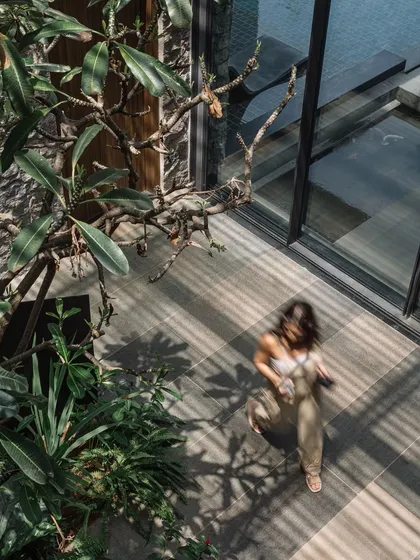 An aerial view of a walkway through the courtyard, capturing the movement and the beautiful patterns of light and shadow on the floor.