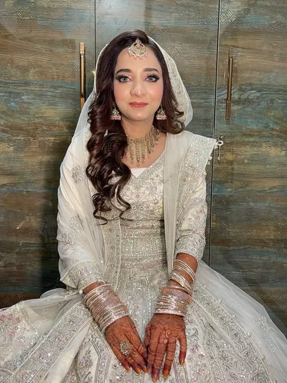 Another angle of this stunning all-white look. The focus is on creating a flawless, glowing complexion that looks both natural and glamorous.