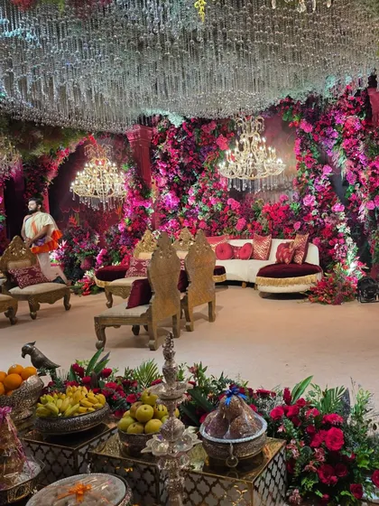 An immersive look into a lavish wedding reception stage, creating a magical floral cave effect. I used thousands of pink and red flowers, complemented by crystal chandeliers and elegant seating to create a truly grand and romantic atmosphere.