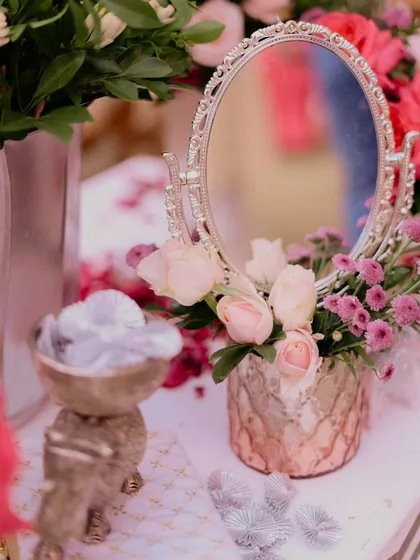 A close-up of a vanity-style corner at a Chooda ceremony, with a vintage silver mirror reflecting blush roses, creating a delicate and feminine vignette.