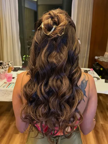 The full back view of the half-up style with soft curls, a versatile look for any pre-wedding event.
