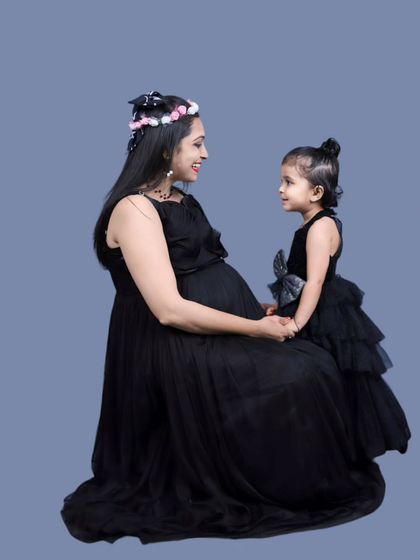 Classic and timeless. This family portrait features our simple black maternity gown paired with a matching black tiered dress for the daughter, creating a chic and coordinated look.