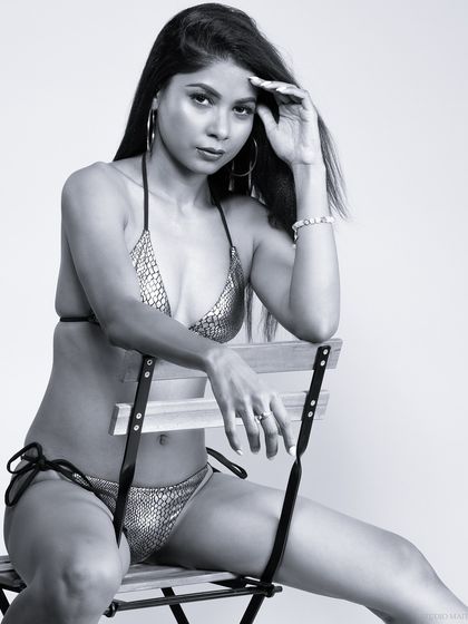 A black and white bikini portrait. The monochrome treatment emphasizes form and shadow, giving the image a classic, artistic quality.