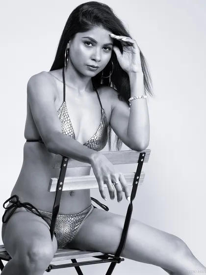 A black and white bikini portrait. The monochrome treatment emphasizes form and shadow, giving the image a classic, artistic quality.