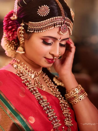 A close-up focusing on the rich details of the Iyengar bridal attire, from the layered necklaces to the intricate headpiece.