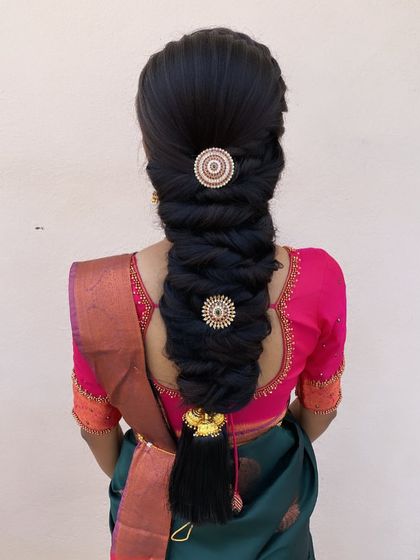 I created this twisted, messy braid and accessorized it with two large, round, stone-studded hairpins for a modern yet traditional look.