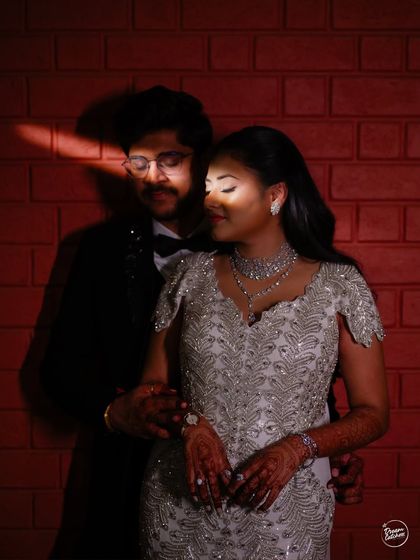 An artistic portrait using a sliver of light to create drama and intimacy. This creative use of shadow against a red brick wall adds a moody and cinematic feel to their cocktail party photos.