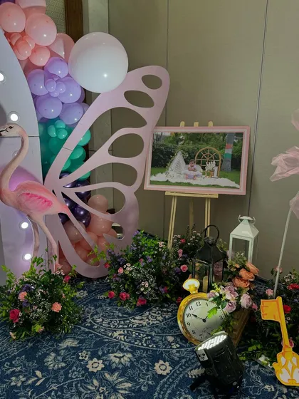 A detail shot of the walkway decor, including a flamingo prop, butterfly wing, and framed photo.