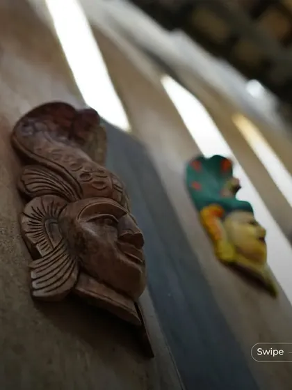 Close-up of carved wooden masks, which are used as decorative elements, adding a touch of folk art and mystique to the walls.