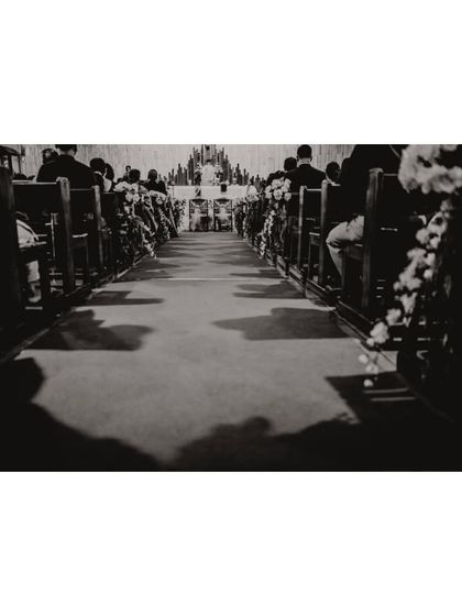 The long walk down the aisle. A black and white shot capturing the grandeur of the church and the anticipation of the ceremony.