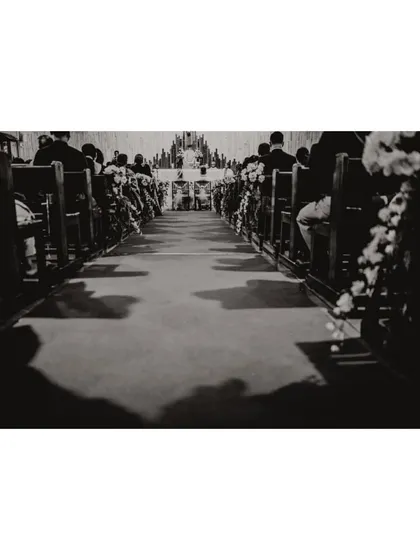 The long walk down the aisle. A black and white shot capturing the grandeur of the church and the anticipation of the ceremony.