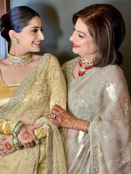 A lovely moment between a mother and daughter, both styled by me. The daughter wears a sleek, modern low bun, showing how I can create complementary looks for family members.