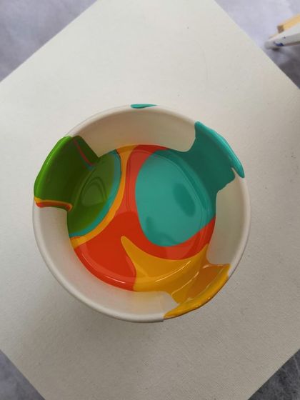 A bowl of layered paints ready to be poured. The combination of colors here promises a bright and energetic final piece.