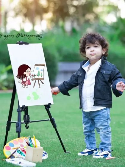 A little boy showing off his artistic side. The painting theme is always a hit, allowing kids to be creative and giving me the chance to capture their focused and proud expressions.