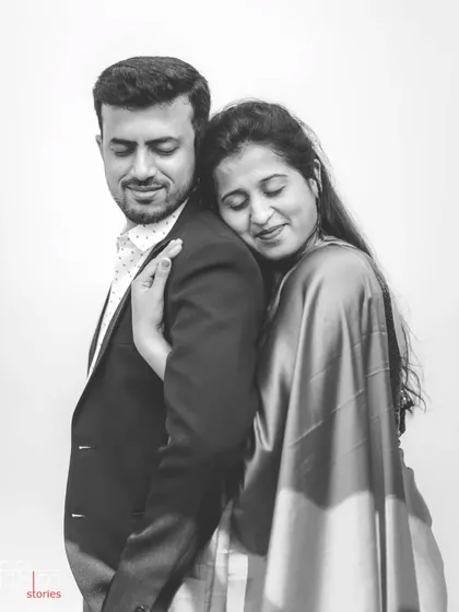 An elegant black and white portrait showing a moment of quiet affection. The simple background and monochrome palette draw all the attention to the couple's tender and peaceful connection.