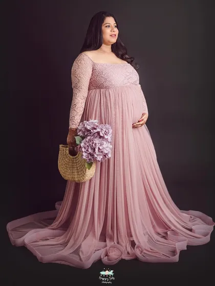 A full-length portrait showcasing the delicate lace details and flowing skirt of this popular pink gown from our client closet.