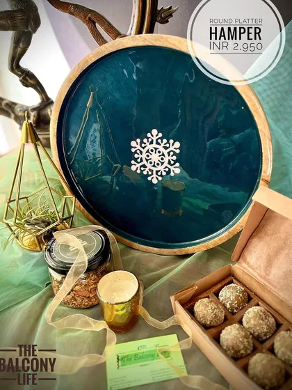 For this hamper, we chose an elegant round platter with a deep teal finish, perfect for serving treats during festive get-togethers. It comes with our favorite upcycled sweets and an air plant in a geometric brass holder, adding a modern touch to your decor. It’s a complete festive starter kit in a box.
