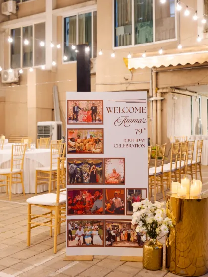 A personalized welcome sets a heartfelt tone. This welcome stand for 'Amma's 79th Birthday' featured a beautiful collage of family photos, celebrating a life full of memories.