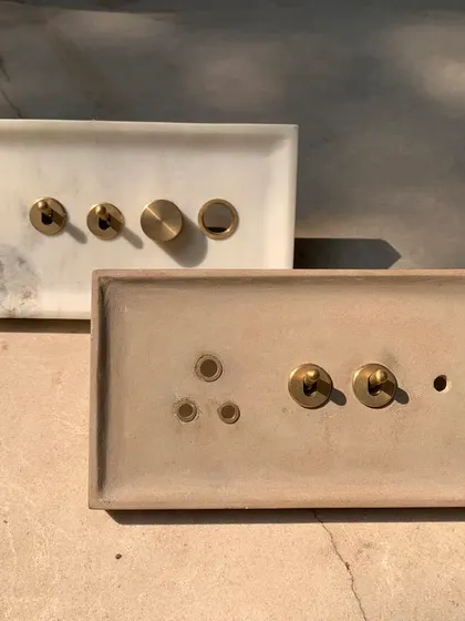 Mockups of our custom-designed switch plates for the House of Galleries, fabricated in marble and stone. These tests allow us to refine the combination of brass fittings with different stone finishes.