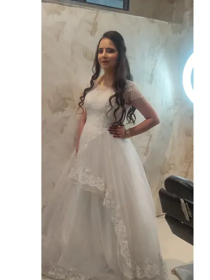 A beautiful white high-low gown with delicate lace detailing. This is a perfect choice for a pre-wedding shoot or a Christian wedding ceremony.
