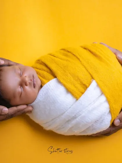 This 'parents' hands' pose is a beautiful way to show connection. The shot, inspired by a mango-vanilla ice cream, uses a yellow and white wrap for a vibrant, warm feel.