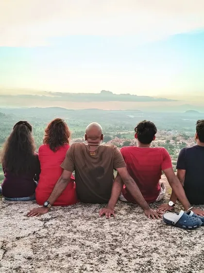 It's not just about the trek, it's about the moments in between. Finding a perfect spot to sit, sharing stories, and just soaking in the view together. This is the community vibe we create on every trip, like this sunset session in Hampi.