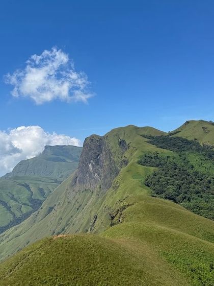 The breathtaking, clear-sky view from Netravathi Peak, showing the unique shape of the surrounding hills.
