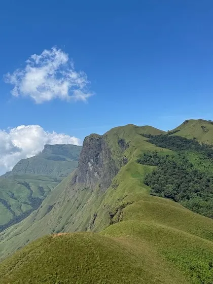 The breathtaking, clear-sky view from Netravathi Peak, showing the unique shape of the surrounding hills.