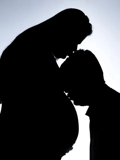 An artistic and intimate silhouette of a dad-to-be kissing the baby bump. This photo is all about emotion and connection.