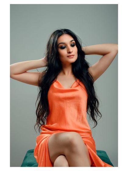 A graceful and elegant portrait in a satin dress. The pose and the soft lighting highlight the flow of the fabric and the model's poise.