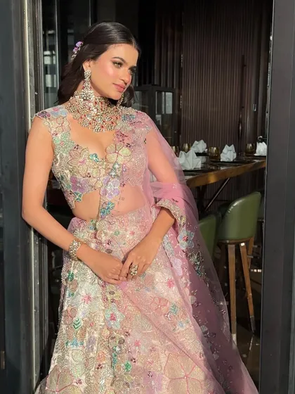 A detailed shot showing the texture and artistry of the floral embroidery on this pastel lehenga, a true work of art.