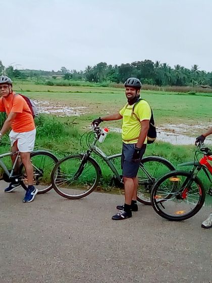Three riders posing with their bikes on a quiet country road during a long-distance tour.