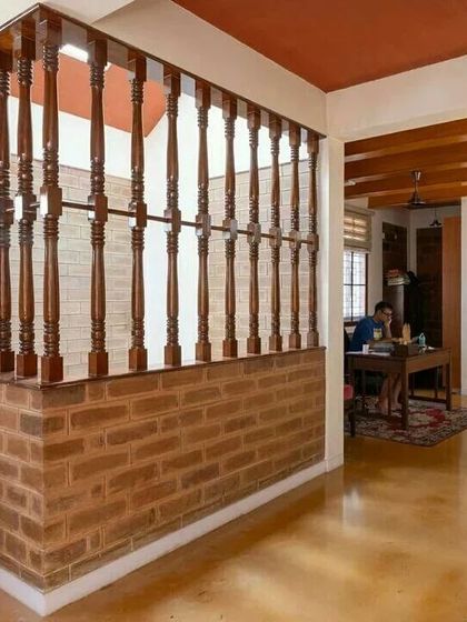 The work-from-home area is visually separated by a traditional wooden railing, maintaining an open feel while defining the space.