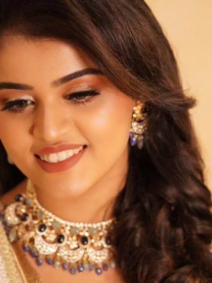 Payal's smile shines as brightly as her makeup. The warm, glittering eyeshadow and soft lipstick create a harmonious and radiant look, perfect for celebrating her reception.