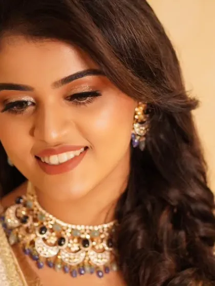 Payal's smile shines as brightly as her makeup. The warm, glittering eyeshadow and soft lipstick create a harmonious and radiant look, perfect for celebrating her reception.