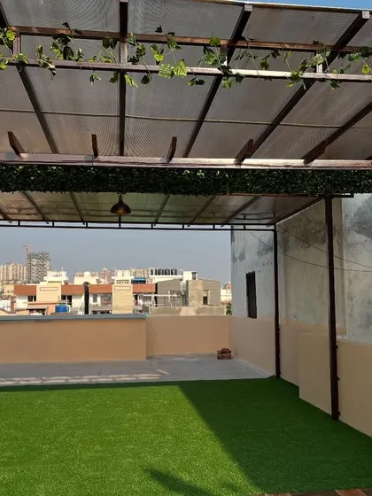 Another angle of the rooftop terrace with artificial grass, showing the full extent of the open, green space created.