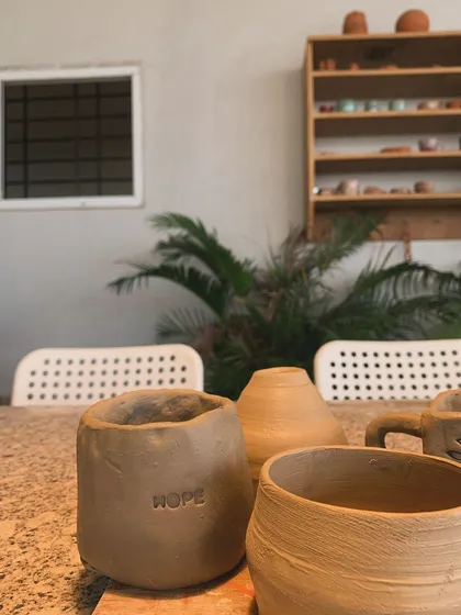 A collection of student works, including a pot with the word 'HOPE' stamped into it. A beautiful reminder of what clay can hold.