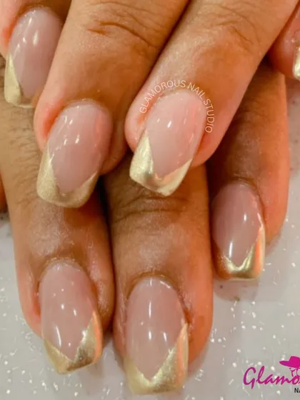 A modern and chic take on the French manicure, this design features a V-shaped tip in metallic gold on a natural base.