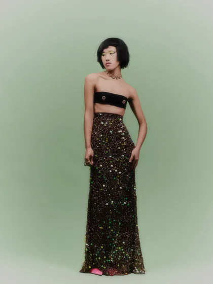 A complete view of the look, where the jewelry adds a touch of opulence to the minimalist bandeau top and sparkling skirt.