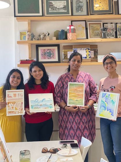 Four participants showing off their beautiful watercolor creations from a weekend workshop.