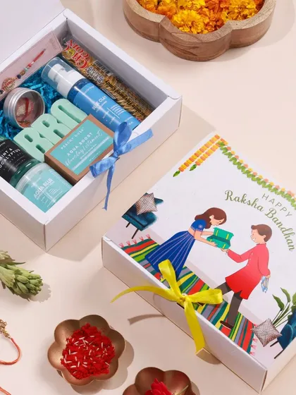Here you can see the blue 'BRO' hamper alongside its beautifully illustrated Raksha Bandhan gift box. The packaging is designed to make the gift feel special from the moment it's received.