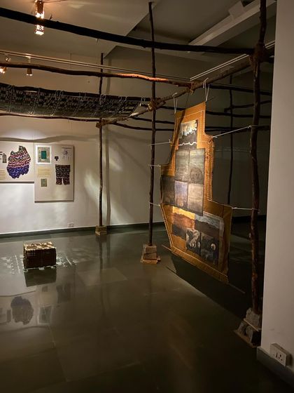 A wider view of the installation, showing the wooden structure that evokes a traditional weaver's loom.