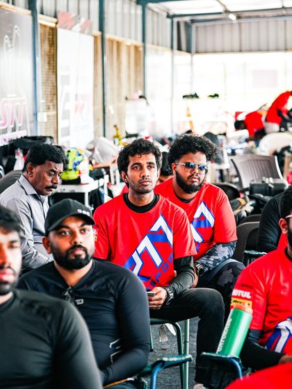 A group of riders listening intently during a classroom session. This testimonial highlights the comprehensive learning experience we provide, both on and off the track.