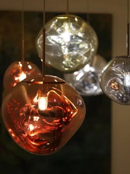 Snippets of hand-blown glass pendant lights in metallic sheens. The organic, molten shapes of these fixtures add a sculptural and artistic quality to the interior.