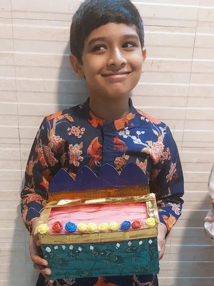 A young boy proudly displays a decorative box he made during our festive workshop. These sessions allow kids to create beautiful, usable items for celebrations like Rakhi or Diwali.
