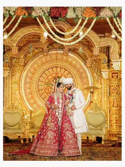 A timeless portrait of the bride and groom against a grand, traditional wedding backdrop. We are experts in capturing the elegance of indoor ceremonies.