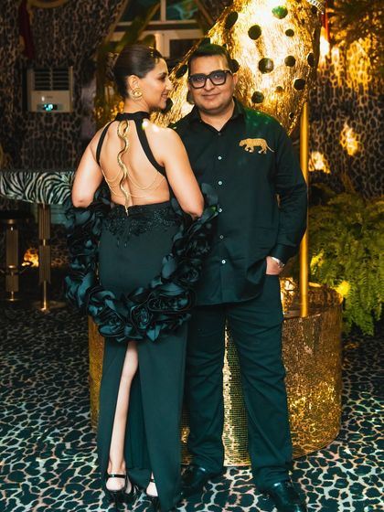 The hosts of the 'Gilded Instinct' party, perfectly dressed to match the glamorous, wild theme of the event.