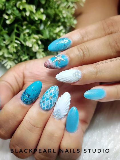 A fully hand-painted, shell-inspired vacation set. This design brings the ocean to your fingertips with 3D shells, mermaid-scale patterns, and glittery blue polish, perfect for a beach getaway.