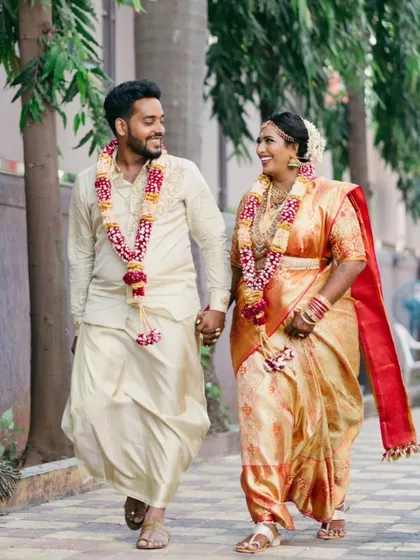 A happy portrait of the couple walking hand-in-hand after their wedding ceremony.