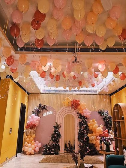 A breathtaking view of the baby shower decor. The ceiling filled with balloons perfectly complements the main backdrop, creating a cohesive and magical environment for the celebration.